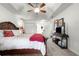 Spacious main bedroom featuring tray ceilings, a ceiling fan, closet doors, and carpeted floors at 1956 Nw 50Th Cir, Ocala, FL 34482