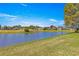 Community pond showcasing scenic views of the surrounding houses and a green fairway at 1956 Nw 50Th Cir, Ocala, FL 34482