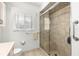 Bright bathroom featuring a tiled walk-in shower with glass door, a window, and neutral tile flooring at 1956 Nw 50Th Cir, Ocala, FL 34482