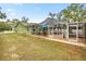 Exterior view of screened-in pool area, with large lot, lush green grass and trees at 20280 Sw 69Th Pl, Dunnellon, FL 34431