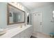 Bright bathroom with a white vanity, large mirror, and access to an exterior door at 20280 Sw 69Th Pl, Dunnellon, FL 34431