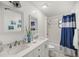 Bright bathroom featuring double sinks, modern fixtures, and a shower-tub combo with blue decorative curtain at 20280 Sw 69Th Pl, Dunnellon, FL 34431