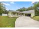 Green single story home featuring covered parking, long driveway and a well maintained lawn at 20280 Sw 69Th Pl, Dunnellon, FL 34431