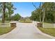 View of single story home featuring a long driveway, covered porch and mature landscaping at 20280 Sw 69Th Pl, Dunnellon, FL 34431