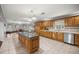 A traditional kitchen features wood cabinets, a central island with sink, and stainless steel appliances at 20280 Sw 69Th Pl, Dunnellon, FL 34431