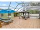 An expansive screened-in patio with a gazebo, lounge chairs, and a glimpse of the refreshing swimming pool at 20280 Sw 69Th Pl, Dunnellon, FL 34431