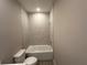 Bathroom featuring a white toilet, white shower/tub and light-grey tile floors at 2602 Sw 154Th Ln, Ocala, FL 34473