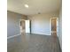 A bedroom boasts wood-look tile flooring, light gray walls, and adjacent access to a bathroom with a glass shower at 2602 Sw 154Th Ln, Ocala, FL 34473