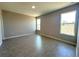 A bedroom with wood-look tile flooring, light gray walls, and large windows with a view at 2602 Sw 154Th Ln, Ocala, FL 34473