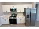 Modern kitchen with white cabinetry, stainless steel appliances, and stone countertops at 2602 Sw 154Th Ln, Ocala, FL 34473