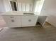 Close-up of the kitchen island with stainless steel sink, white cabinets, and tile flooring at 2602 Sw 154Th Ln, Ocala, FL 34473