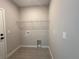 A laundry room with wood-look tile flooring, utility connections, and a wire shelf for storage at 2602 Sw 154Th Ln, Ocala, FL 34473