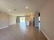 Open-concept living space with wood-look tile flooring and a kitchen island in the background at 2602 Sw 154Th Ln, Ocala, FL 34473