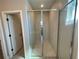 A glass shower with neutral tile is featured in a home bathroom with tile floor at 2602 Sw 154Th Ln, Ocala, FL 34473