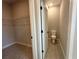 A walk-in closet is shown adjacent to the toilet, complete with shelving, and gray floors at 2602 Sw 154Th Ln, Ocala, FL 34473