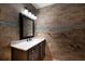 Bathroom featuring earth-tone tiling, a decorative mirror, and a dark vanity at 4301 Se 6 Ave, Ocala, FL 34480