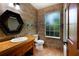 Full bathroom features a wood vanity and earth-toned tile at 4301 Se 6 Ave, Ocala, FL 34480