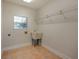 Bright laundry room with utility sink, tile flooring, window, and shelving for ample storage at 4301 Se 6 Ave, Ocala, FL 34480