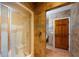 Shower with a glass door, tile surround, and built-in seat, next to a doorway to the bathroom at 4301 Se 6 Ave, Ocala, FL 34480