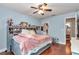 Bright bedroom featuring hardwood floors, a ceiling fan, and a queen-sized bed at 4839 Sw 63Rd St, Ocala, FL 34474