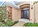 Inviting front entrance with a dark door, detailed trim, and lush landscaping, creating a warm welcome at 4839 Sw 63Rd St, Ocala, FL 34474