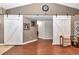 View of the living room area with beautiful white barn doors and hardwood flooring at 4839 Sw 63Rd St, Ocala, FL 34474
