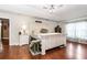 Comfortable main bedroom with tray ceiling, a ceiling fan, hardwood floors, and a large bed at 4839 Sw 63Rd St, Ocala, FL 34474