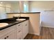 Bathroom features double sink vanity with black countertop and white cabinets at 5646 Sw 129Th Place Rd, Ocala, FL 34473