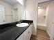 Bathroom features a single sink vanity with a black countertop at 5646 Sw 129Th Place Rd, Ocala, FL 34473
