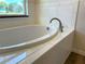 Close up of a tiled bathtub with chrome fixtures and a window at 5646 Sw 129Th Place Rd, Ocala, FL 34473
