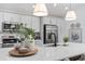 Kitchen island with white countertop, stainless steel appliances, and modern decor for a warm ambiance at 6918 Baysinger Path, The Villages, FL 34762