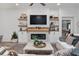 Modern living room featuring a fireplace, TV, floating shelves, and stylish decor at 6918 Baysinger Path, The Villages, FL 34762