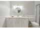 White bathroom with a vanity, round mirror, and wainscoting at 8430 Sw 90Th Ln # A, Ocala, FL 34481