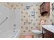 Cozy bathroom features a tub and shower, decorative wallpaper, and ample cabinet storage for toiletries at 8430 Sw 90Th Ln # A, Ocala, FL 34481