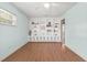 Open-concept room with a large built-in bookcase and light hardwood flooring, creating a bright and inviting living space at 8430 Sw 90Th Ln # A, Ocala, FL 34481