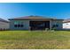 Wide shot of the backyard with screened in patio and well maintained grass at 8843 Sw 57Th Place Rd, Ocala, FL 34481