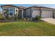 Charming home featuring lush lawn, stone-lined flowerbeds, and a two-car garage at 8843 Sw 57Th Place Rd, Ocala, FL 34481
