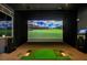 A high-end indoor golf simulator room in a home with a large screen and comfortable putting space at 8843 Sw 57Th Place Rd, Ocala, FL 34481