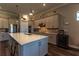Modern kitchen with an island, pendant lights, stainless steel appliances, and gray cabinets at 8843 Sw 57Th Place Rd, Ocala, FL 34481