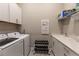 Clean and organized laundry room with washer, dryer, sink, and storage, designed for functionality at 8843 Sw 57Th Place Rd, Ocala, FL 34481