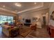 Bright living room with tray ceilings, hardwood floors, comfortable seating, and a large window at 8843 Sw 57Th Place Rd, Ocala, FL 34481