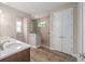 Bathroom featuring double doors, glass shower with pebbles, and wood grain floors at 10314 Sw 96Th Loop, Ocala, FL 34481