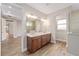 Bathroom with a double sink, dark cabinets, mirrors, and modern lighting at 10314 Sw 96Th Loop, Ocala, FL 34481