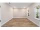 Well-lit bedroom showcasing wood-look flooring, neutral paint, and ample natural light from the windows at 10314 Sw 96Th Loop, Ocala, FL 34481