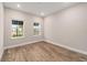 Bright bedroom featuring wood-look flooring and windows with outdoor views, perfect for a peaceful retreat at 10314 Sw 96Th Loop, Ocala, FL 34481