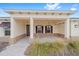 Inviting front porch with stone pavers, decorative columns, and craftsman-style lighting fixtures at 10314 Sw 96Th Loop, Ocala, FL 34481