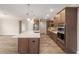 Modern kitchen features a large island, stainless steel appliances, and brown cabinets at 10314 Sw 96Th Loop, Ocala, FL 34481