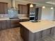 Well-equipped kitchen with a central island, a stainless range hood, and tiled backsplash at 10314 Sw 96Th Loop, Ocala, FL 34481