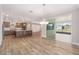 Open-concept living room and kitchen featuring wood floors and sliding glass door at 10314 Sw 96Th Loop, Ocala, FL 34481