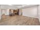 Open-concept living room with wood-look flooring, seamlessly connecting to the kitchen with stainless steel appliances at 10314 Sw 96Th Loop, Ocala, FL 34481